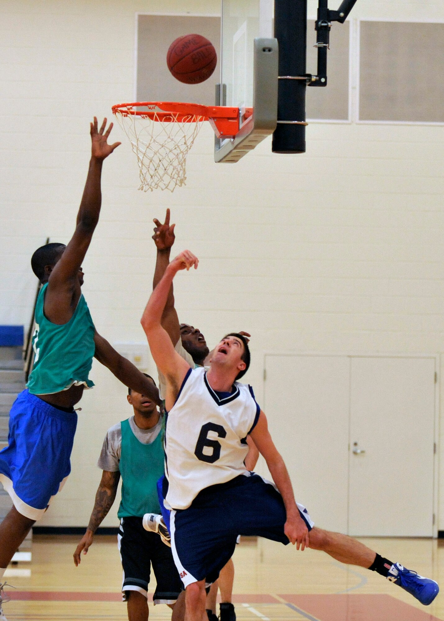 Hunter Myers, 436th Communications Squadron player-coach, drives to the hoop for a reverse layup while 436th Security Forces Squadron defenders attempt to block during an intramural basketball game Feb. 2, Dover Air Force Base, Del. Myers scored a game-high 17 points to lead the 436th CS to an upset victory against the 436th SFS 46-31. (U.S. Air Force photo by Tech. Sgt. Chuck Walker)