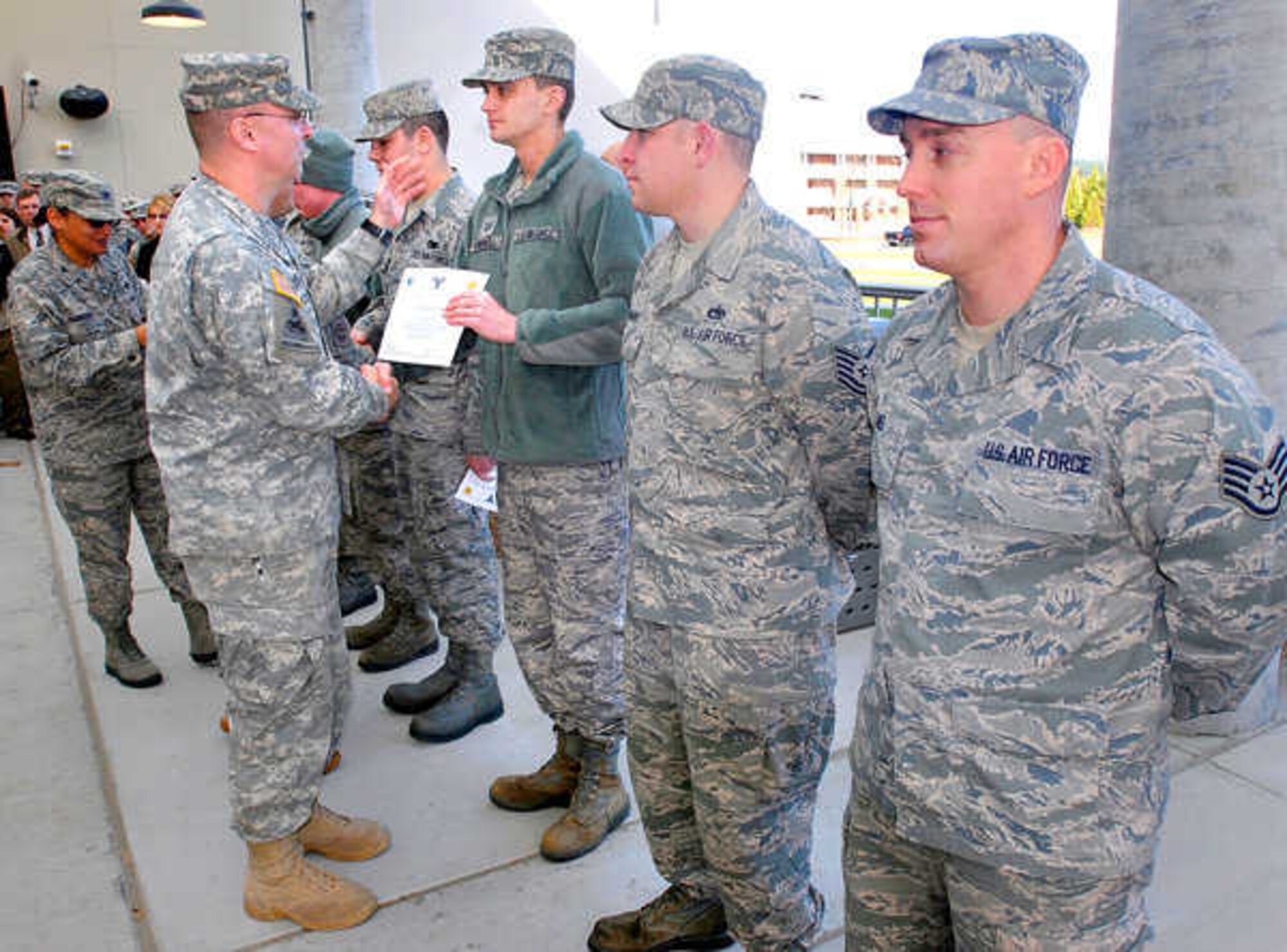 Col. Thomas Brittain, Joint Base Lewis-McChord garrison commander, congratulates Tech. Sgt. Sean Cornwell, 627th Logistics Readiness Squadron, for a job well done during efforts continue to recover the storm damage Jan. 26, 2012, at Joint Base Lewis-McChord, Wash. (U.S. Air Force courtesy photo/Scott Hansen)