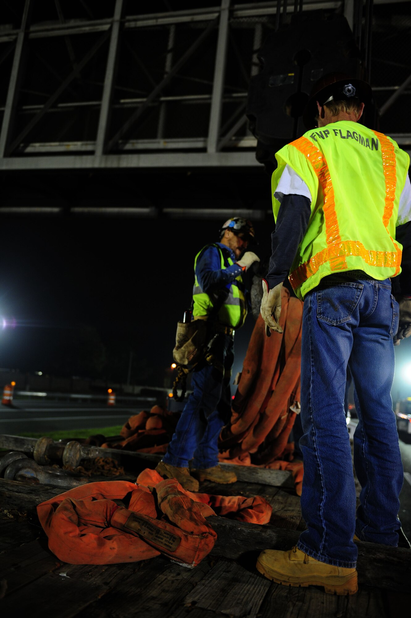 Construction workers secure load bearing straps to a crane on U.S. Highway 98, Mary Esther, Fla., Feb. 5, 2012.  The straps are being used to lift the approximately 160,000 pound pedestrian bridge to the side of the road to receive maintenance. (U.S. photo/Airman 1st Class Gustavo Castillo)(Released)