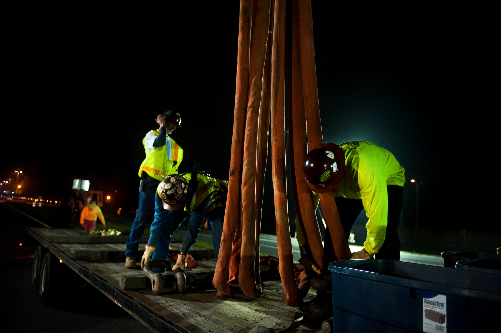 Construction workers prepare load-bearing straps to lift the pedestrian bridge on U.S. Highway 98 in Mary Esther, Fla., for repair, Feb. 05, 2012. The bridge is being temporarily relocated for repair. (U.S. Air Force photo/Airman 1st Class Christopher Williams)(Released)