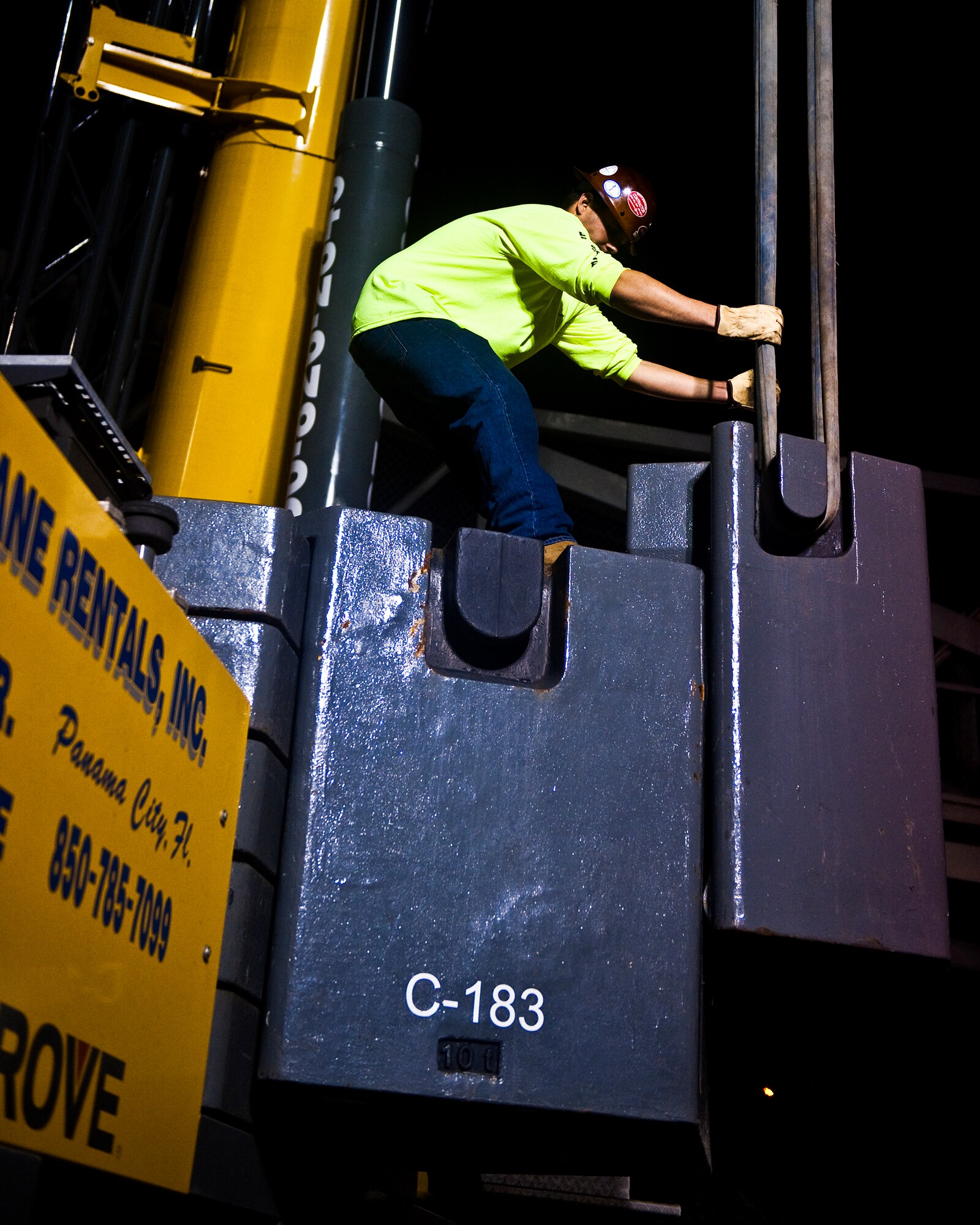 A construction worker, on U.S. Highway 98 in Mary Esther, Fla., positions a counter-weight on the crane to help balance the crane and bridge?s weight as it?s moved for repair, Feb. 05, 2012. The pedestrian bridge crosses over Highway 98 connecting Hurlburt Field Main to Hurlburt Field Soundside. (U.S. Air Force photo/Airman 1st Class Christopher Williams)(Released)