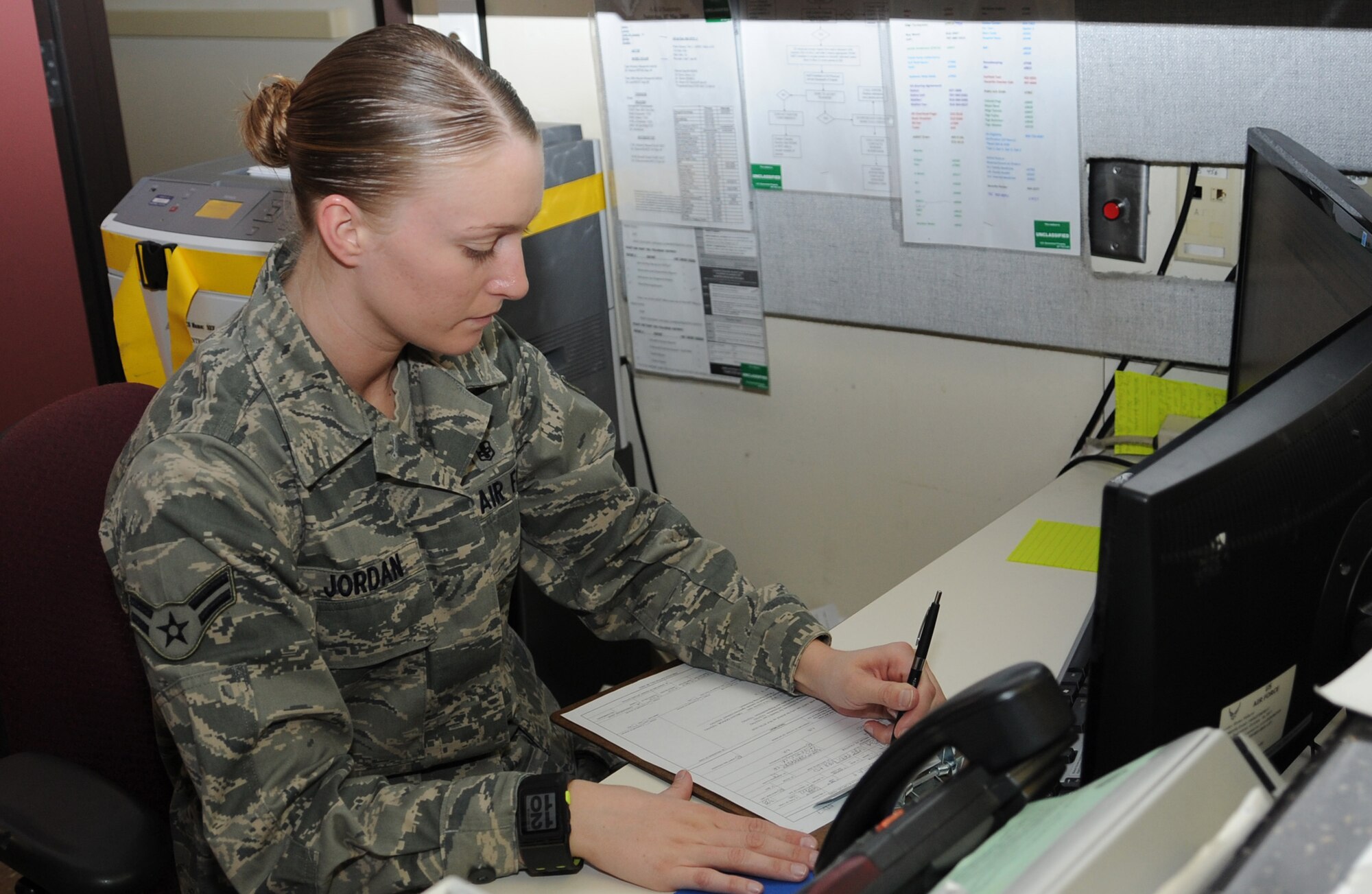Airman 1st Class Lindsey Jordan, medical administrator, checks patient forms at the admissions call center at David Grant USAF Medical Center. (U.S. Air Force photo/ Staff Sgt. Liliana Moreno)