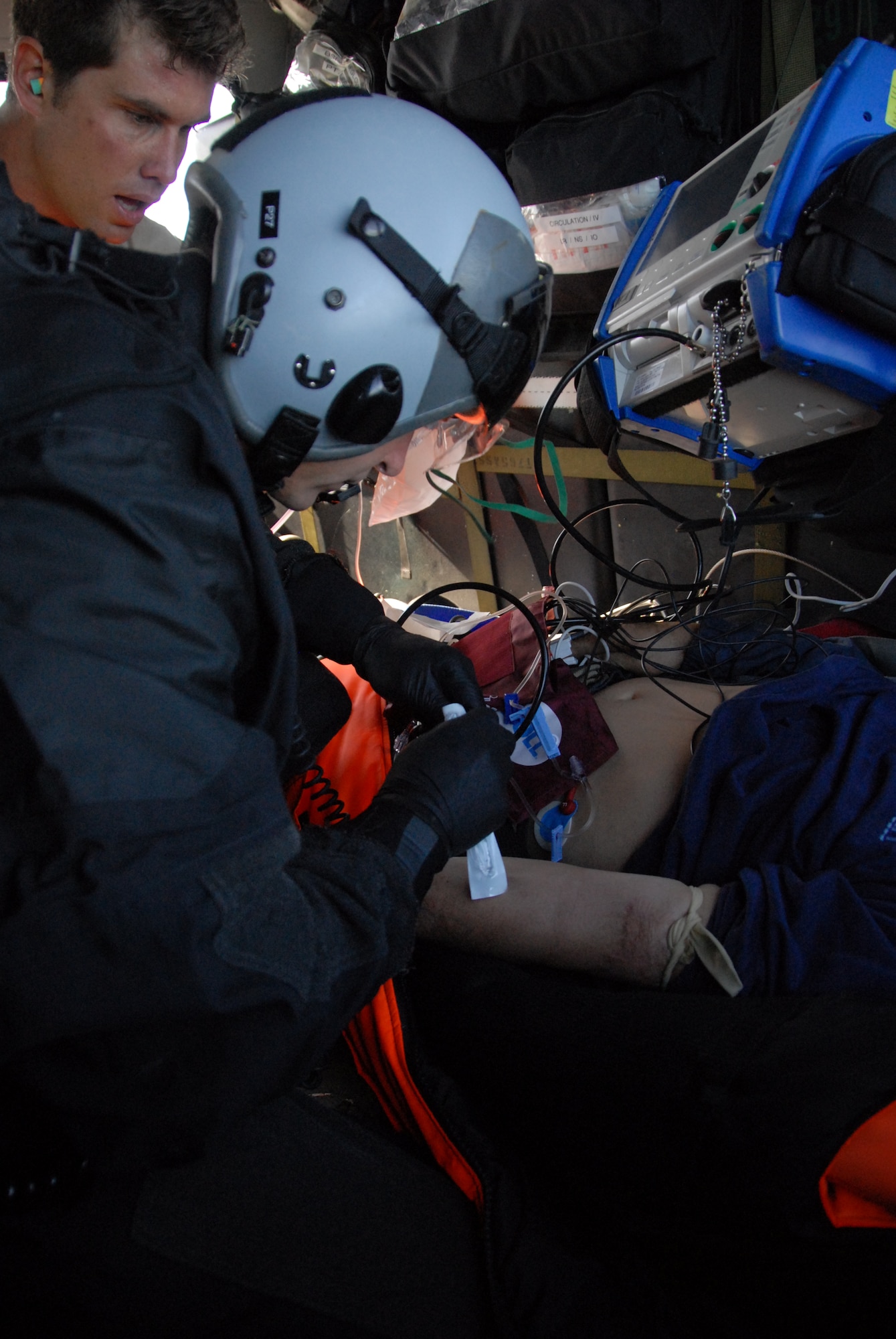 Master Sgt. Jimmy Petrolia sets up an IV drip for the patient in preparation for transport Feb. 4, 2012, 200 miles of the coast of California. Guardsmen from the 129th Rescue Wing medically evacuated a man who suffered stroke-like symptoms to the San Jose Regional Medical Center in San Jose, Calif. Petrolia is a pararescueman assigned to the 131st Rescue Squadron, which is out of Moffett Federal Airfield, Calif. (Air National Guard photo/Senior Airman Jessica Green)