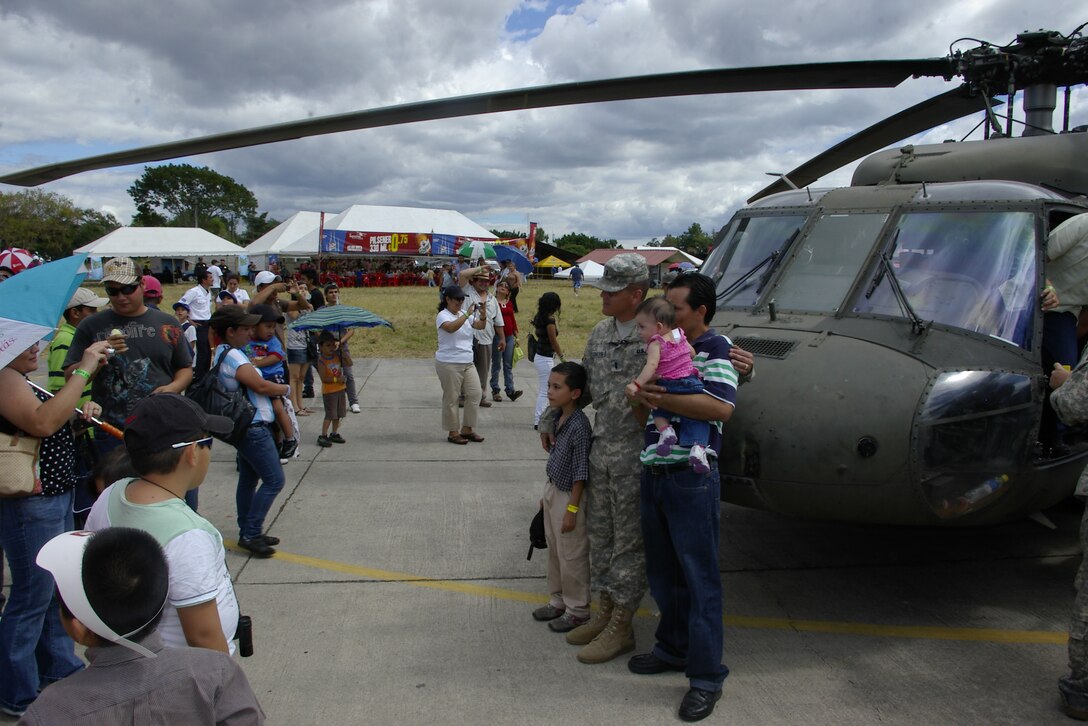 SAN SALVADOR, El Salvador - Army 1st Lt. Jimmy Cogles, a 1st Battalion, 228th Aviation Regiment pilot, poses for pictures during the annual Ilopango Air Show at Ilopango International Airport last month.  Members of the battalion and the 612th Air Base Squadron represented Joint Task Force-Bravo, Soto Cano Air Base, Honduras, at the 2012 air show. Airmen and Soldiers were on hand to answer questions and pose for pictures as an estimated 35,000 people enjoyed the sights, sounds, and smells at one of the largest air shows in Central America. (Air Force photo/Lt. Col. Lloyd Malone)