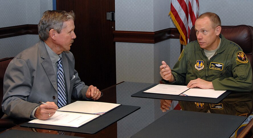 Scott Blanch, AFGE Council 214 president, and Gen. Donald Hoffman, AFMC commander, discuss command updates before signing a new master labor agreement here Feb. 2, 2012.  The master labor agreement  is a contract between AFGE Council 214 and AFMC that governs matters affecting bargaining unit employees’ working conditions. (U.S. Air Force photo/Ben Strausser)
