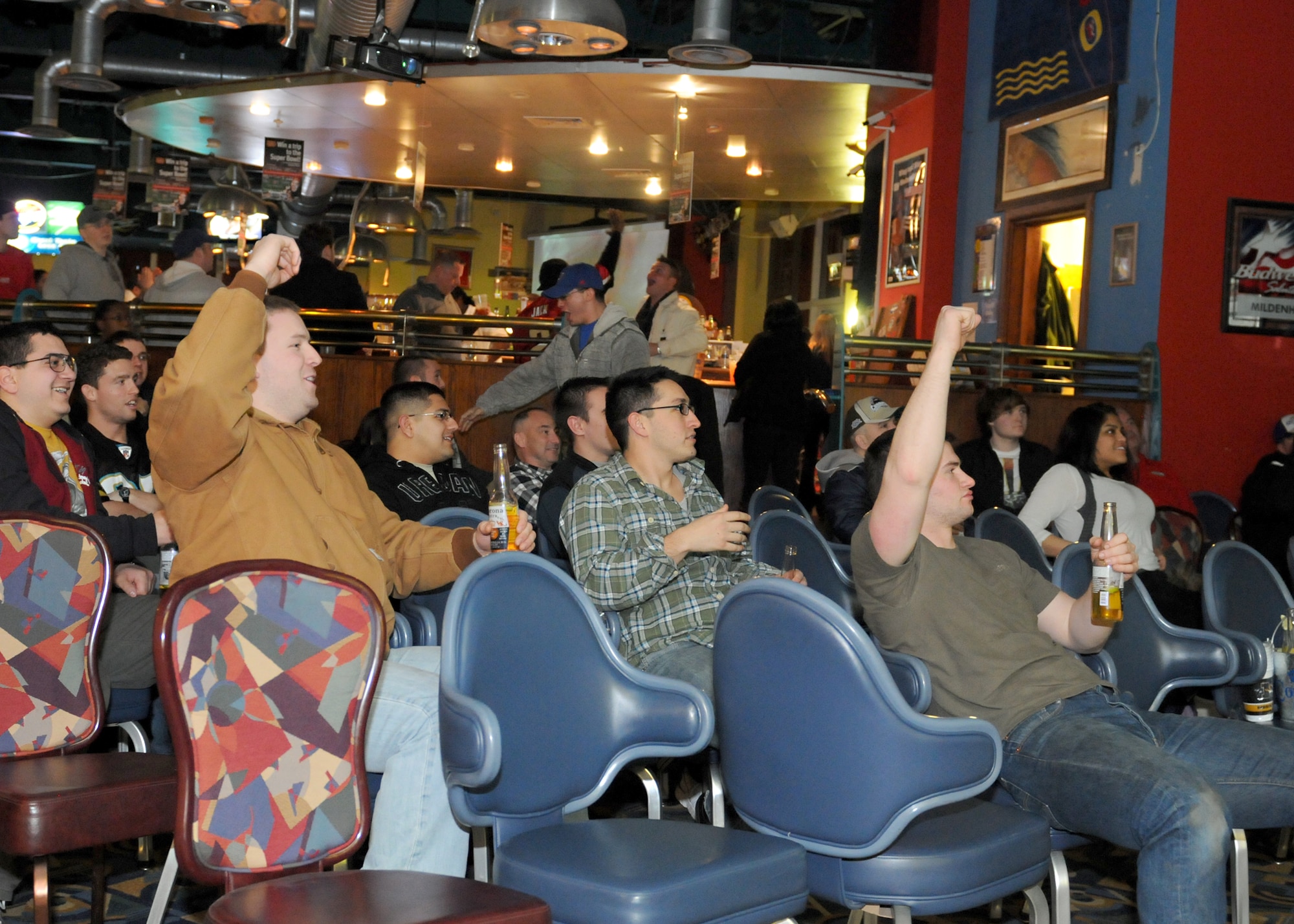 RAF MILDENHALL, England – Members of Team Mildenhall cheer for their 2012 Superbowl pick at the Galaxy club Superbowl party here Feb. 5, 2012.  The Galaxy Club offered fun, food and beverages, and allowed military members to enjoy the  American pastime of watching the Superbowl. (U.S. Air Force photo/Staff Sgt. Tabitha M. Lee)