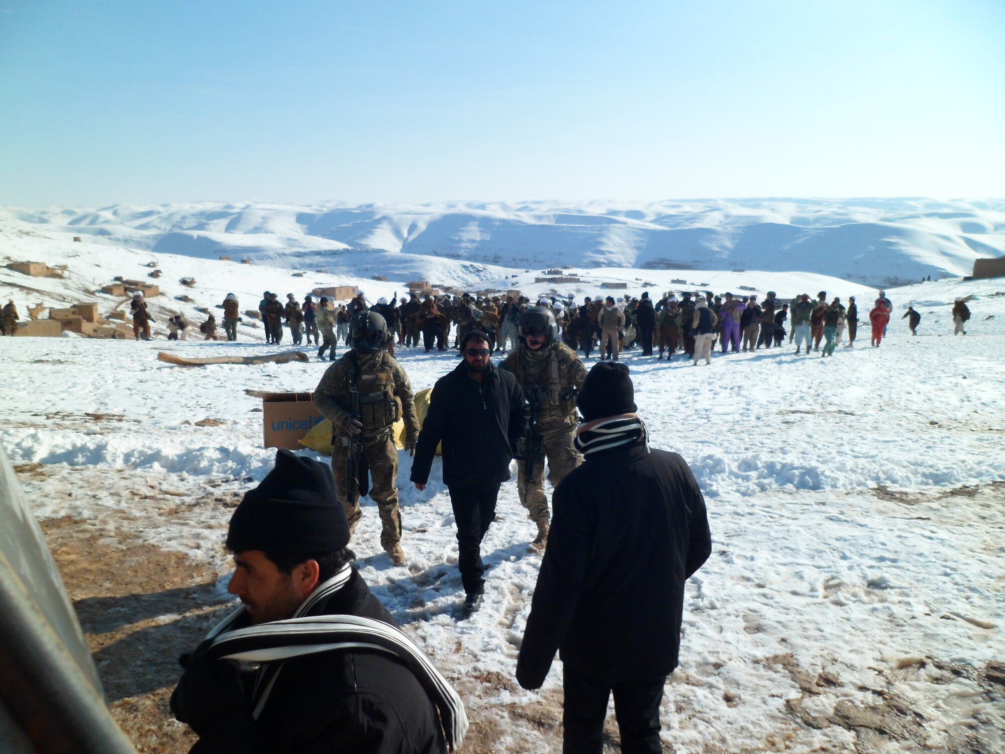 Advisers from the 738th Air Expeditionary Advisory Group assist in a drop of humanitarian supplies Jan. 27, 2012 at a remote village in Afghanistan.(courtesy photo)