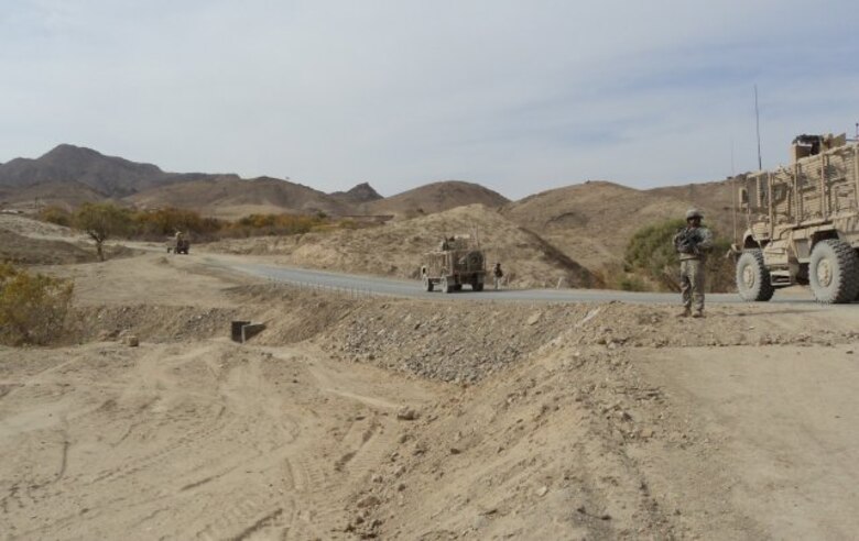 U.S. Army Corps of Engineers Mine-resistant, ambush-protected vehicles and security line a portion of Route Bear as USACE personnel inspect construction in December 2011.
