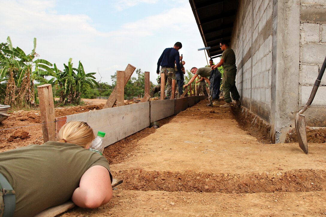 U.S. Marine Corps Cpl. Elizabeth Annand, left, checks the depth of a trench during construction of a multipurpose building at the Ban Khunsong School as part of Cobra Gold 2012 in Chanthaburi, Thailand, Jan. 31, 2012. Annand is assigned to Marine Wing Support Squadron 172.