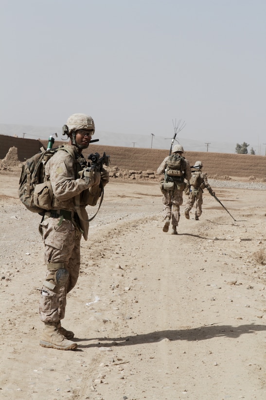 Cpl. Adam McKinley, squad leader with 2nd platoon, Weapons Company, 3rd Battalion, 7th Marine Regiment, instructs his squad members during a security patrol here recently. McKinley, a 24-year-old native of Sacramento, Calif., strictly followed the route of the pointman, who scanned the area for improvised explosive devices and enemies.