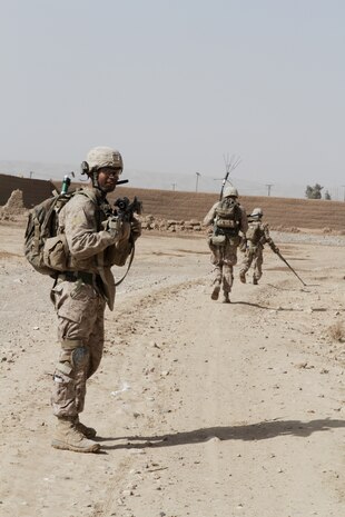 Cpl. Adam McKinley, squad leader with 2nd platoon, Weapons Company, 3rd Battalion, 7th Marine Regiment, instructs his squad members during a security patrol here recently. McKinley, a 24-year-old native of Sacramento, Calif., strictly followed the route of the pointman, who scanned the area for improvised explosive devices and enemies.