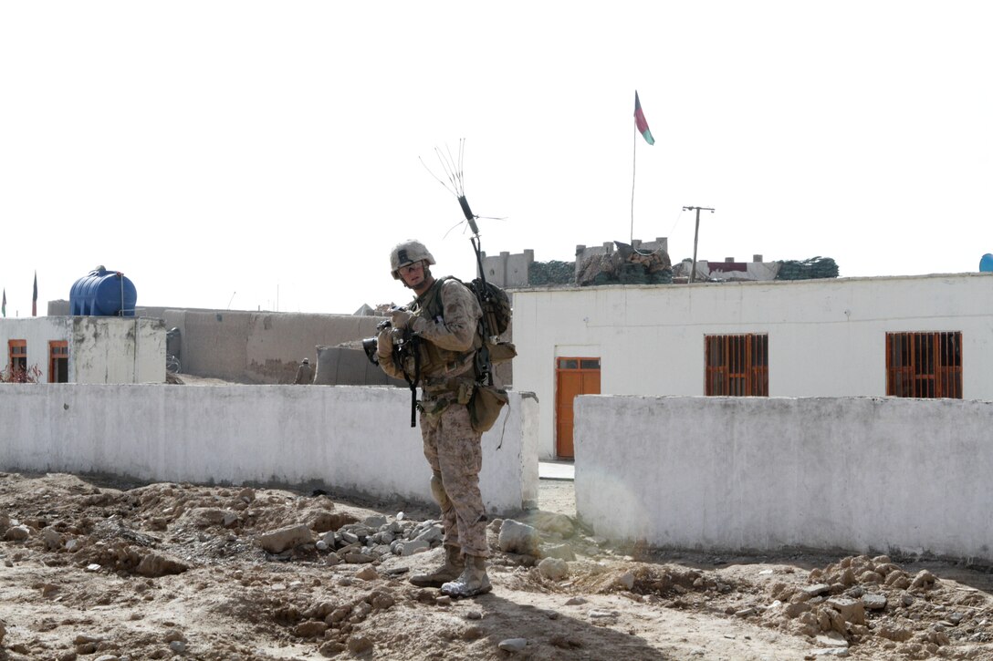 Lance Cpl. Ryan W. Scoville, team leader with Weapons Company, 3rd Battalion, 7th Marine Regiment, a 22-year-old Peoria, Ariz., native, receives instruction from his squad leader during a security patrol here, recently. He carried a THOR jamming system to disrupt remote-detonated improvised explosive devices.