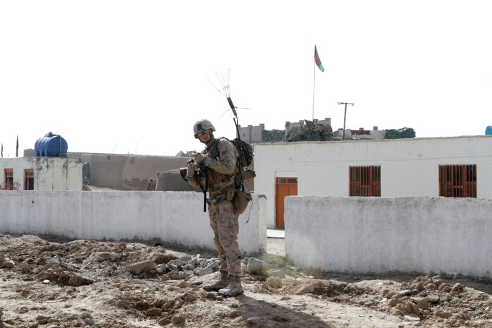 Lance Cpl. Ryan W. Scoville, team leader with Weapons Company, 3rd Battalion, 7th Marine Regiment, a 22-year-old Peoria, Ariz., native, receives instruction from his squad leader during a security patrol here, recently. He carried a THOR jamming system to disrupt remote-detonated improvised explosive devices.