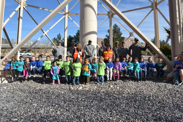 Airmen from the 99th Civil Engineer Squadron pose for a group photo with children from the Nellis Child Development Center during a field trip Jan. 27, 2012, on Nellis Air Force Base, Nev.  The Airmen taught the children about the base water tower and other “giants” located around the base.  (Courtesy photo)