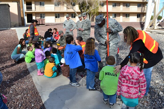 Airmen from the 99th Civil Engineer Squadron accompanied children from the Nellis Child Development Center during a field trip Jan. 27, 2012, on Nellis Air Force Base, Nev.  The Airmen taught the children about the base water tower and other “giants” located around the base.  (Courtesy photo)