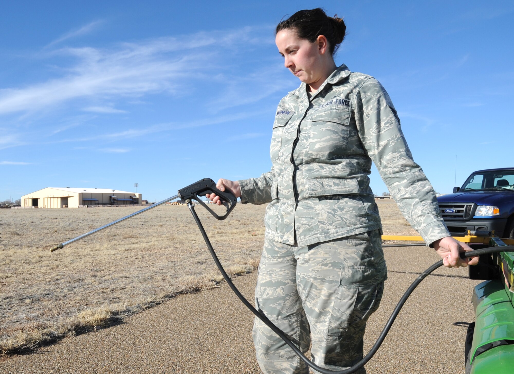 U.S. Air Force Senior Airman C?Belle Tennimon sprays weed killer near the flightline at Cannon Air Force Base, N.M., Feb. 1, 2012. Tennimon is a pest manager who routinely deals with public health concerns at Cannon. (U.S. Air Force photo by Airman 1st Class Alexxis Pons Abascal)  