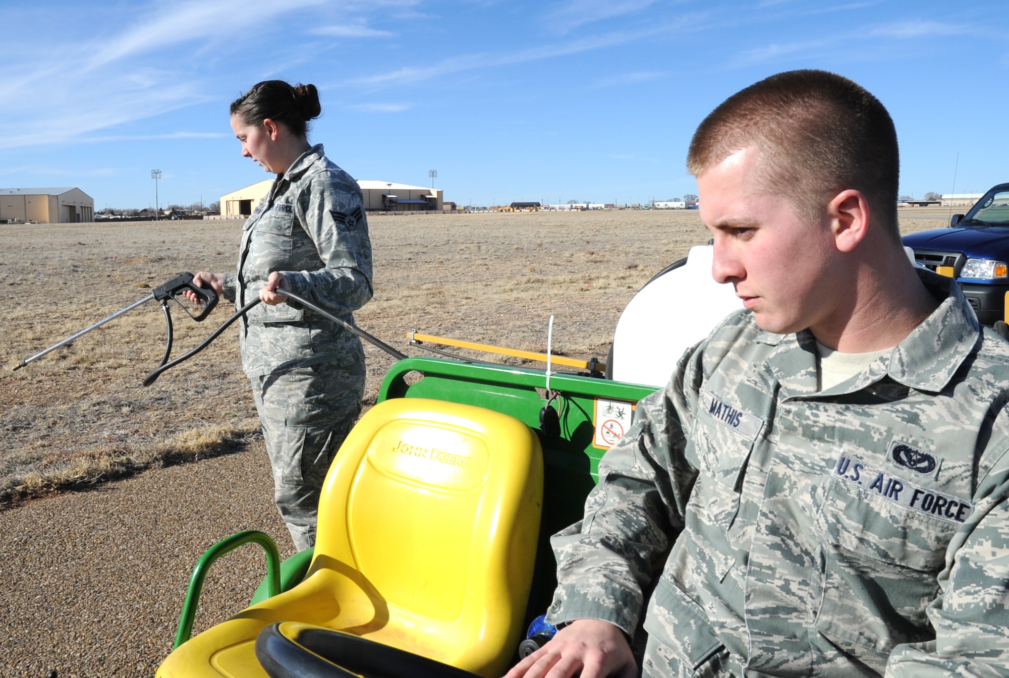 U.S. Air Force Senior Airman C?Belle Tennimon sprays weed killer while Airman 1st Class Jacob Mathis navigates their vehicle near the flightline at Cannon Air Force Base, N.M., Feb. 1, 2012. Both Air Commandos are pest managers who routinely deal with public health concerns at Cannon. (U.S. Air Force photo by Airman 1st Class Alexxis Pons Abascal)  