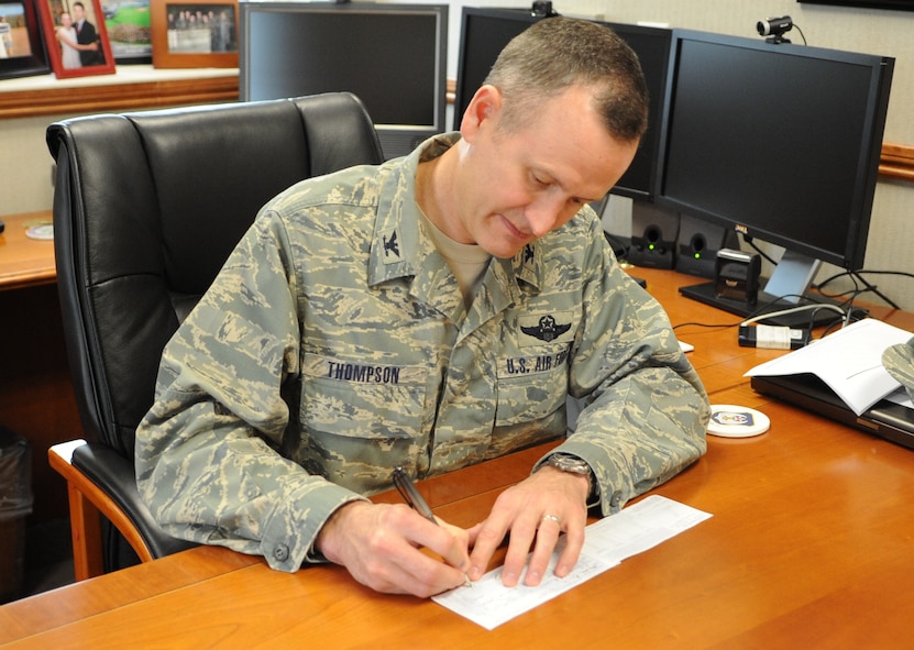 U.S. Air Force Col. Billy Thompson, 23d Wing commander, fills out his contribution form for the Air Force Assistance Fund (AFAF) at Moody Air Force Base, Ga., Feb. 7, 2012. The AFAF began Feb. 6 and will run through Mar. 16. Moody's goal is to raise $81,379.  (U.S. Air Force photo by Staff Sgt. Melissa K. Mekpongsatorn/Released)