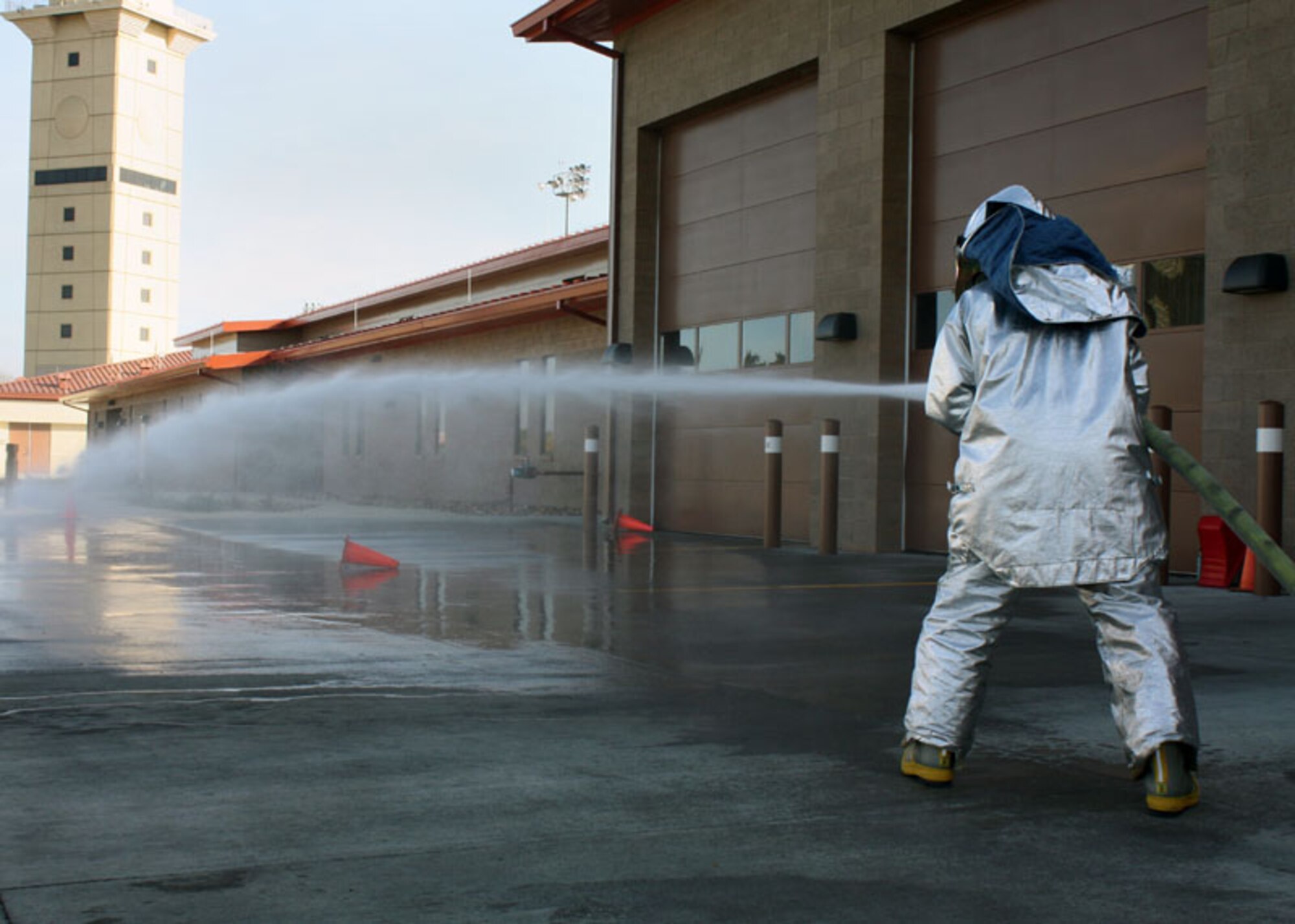 Senior Airman Jamie Perkins, 349th Civil Engineer Squadron firefighter, uses a hand line hose to knock down safety cone targets during training here Jan. 8. Reserve Airmen conducted joint training with their active-duty counterparts from the 60th
Civil Engineer Squadron over the weekend. (U.S. Air Force photo/Tech. Sgt.
Rachel Martinez)
