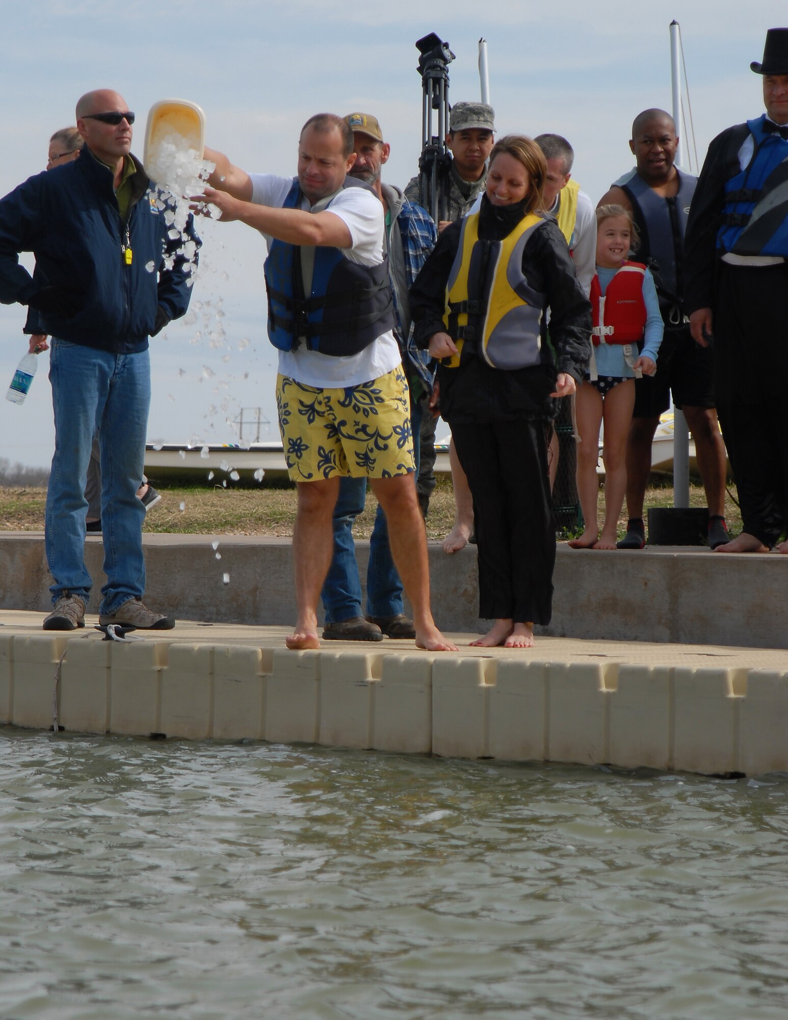 GOODFELLOW AIR FORCE BASE, Texas-- Col. Mark Damiano, 17th Training Wing Commander, pours a bucket of ice into Lake Nasworthy, kicking off the annual Polar Bear Swim at the Goodfellow Recreational Camp Feb. 4. A total of 311 registered swimmers jumped into the 38 degree water for the morale boosting event. (U.S. Air Force photo/Airman 1st Class Michael Smith)
