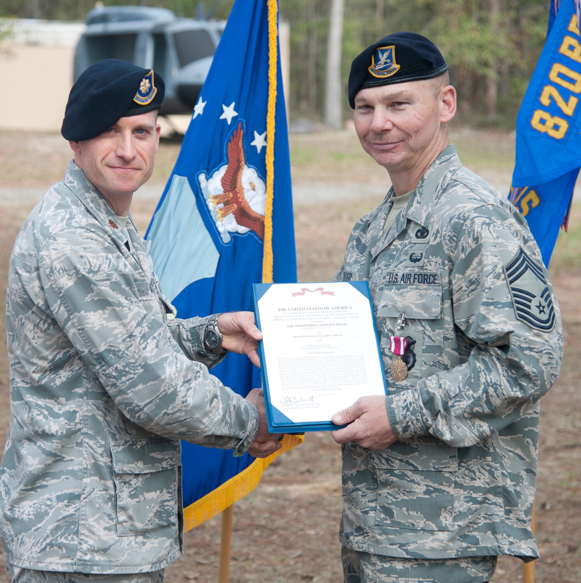 U.S. Air Force retired Chief Master Sgt. Larry Miller, 824th Base Defense Squadron security forces manager, receives his retirement certificate from Maj. James Meier, 824th BDS commander, at Moody Air Force Base, Ga., Feb. 3, 2012. Meier reflected on Miller’s career and how he influenced many Airmen over the years. (U.S. Air Force Photo by Airmen 1st Class Paul Francis/Released)
