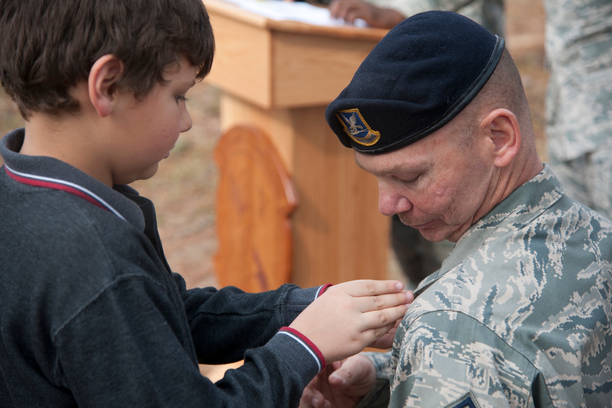 U.S. Air Force retired Chief Master Sgt. Larry Miller, 824th Base Defense Squadron security forces manager, receives his retirement pin from his son Ryan Miller at Moody Air Force Base, Ga., Feb. 3, 2012. Miller served 28 years in active duty and has been stationed at nine bases since enlisting in 1984. (U.S. Air Force Photo by Airmen 1st Class Paul Francis/Released)
