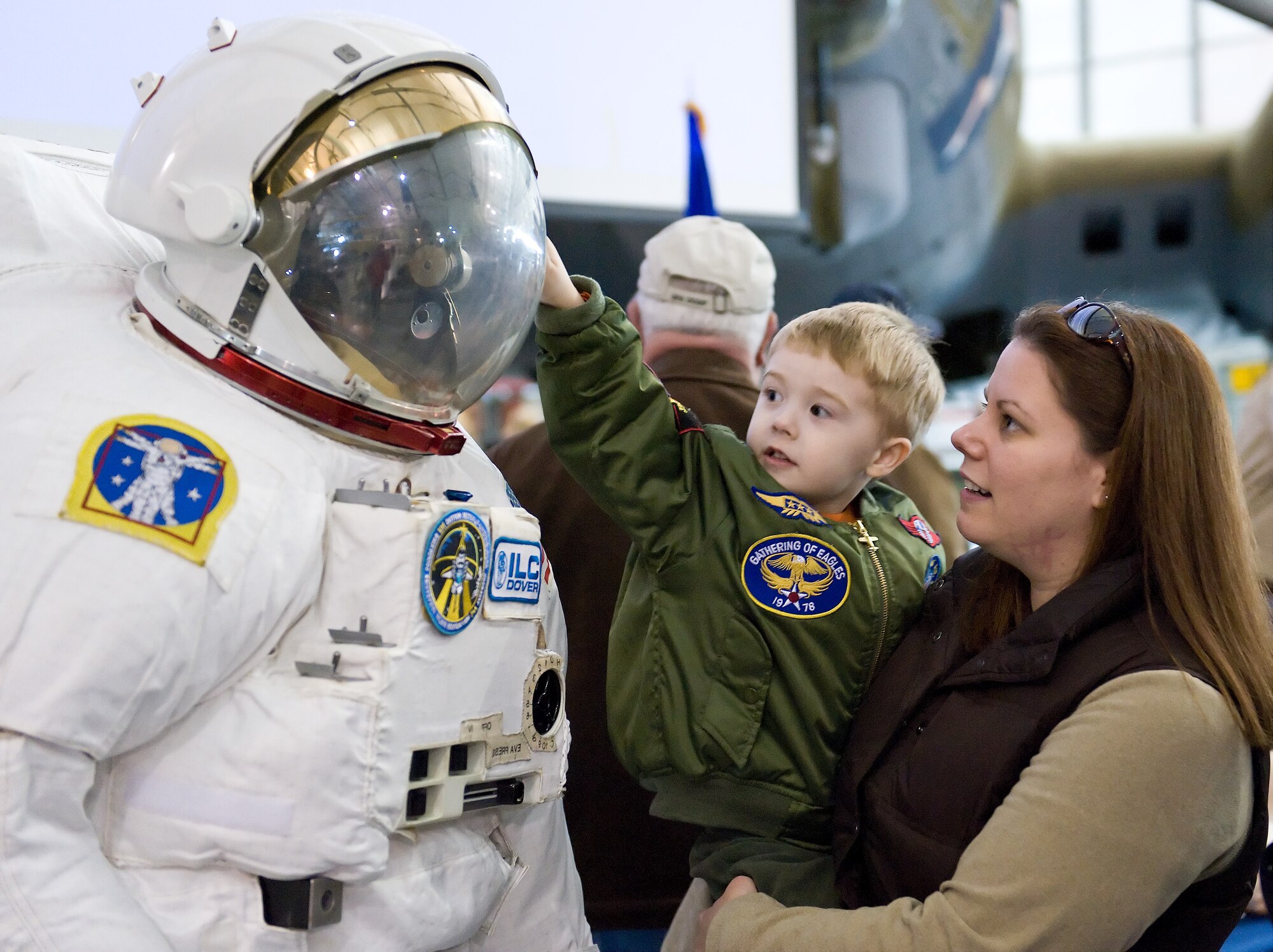 Mark Hitzig, left, and his mother, Ashley, interact with a real-life spacesuit presented by ILC-Dover for a program titled “Hangar Flying” Feb. 5, 2012, at the Air Mobility Command Museum in Dover, Del. Hangar Flying is a series of educational presentations relating to the United States Armed Forces. (U.S. Air Force photo by Roland Balik)