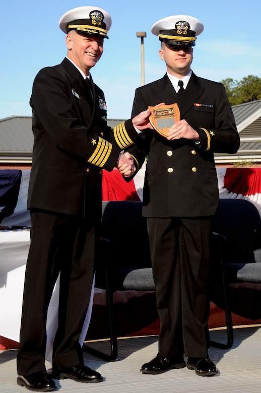 Ensign Kevin Plumer receives the Vice Adm. Behrens award from Capt. Dennis Carpenter during the Naval Nuclear Power Training Command graduation ceremony for class 1106 at Joint Base Charleston - Weapons Station, Feb. 3. The Behrens award recognizes the graduating officer with the highest grade-point average. Plumer earned an overall GPA of 3.87.  Carpenter is the Submarine Squadron 19 commander. (U.S. Navy photo/Petty Officer 2nd Class  Brannon Deugan)