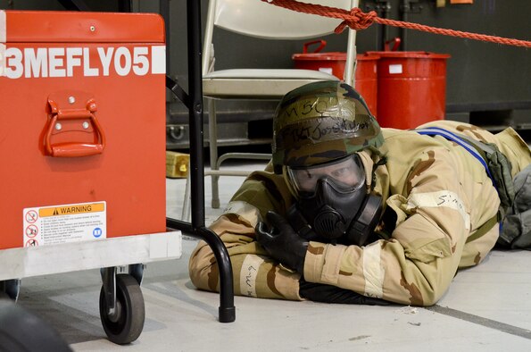 Air National Guardsman Tech. Sgt. Joseph Wood, 116th Maintenance Squadron, takes cover under a table while wearing his Individual Protective Equipment during a simulated attack at Robins Air Force Base, Ga., Feb. 3, 2012. The simulated attack occurred during an Operational Readiness Exercise being conducted by the 116th and 461st Air Control Wings. (Air Force photo by Master Sgt. Roger Parsons)