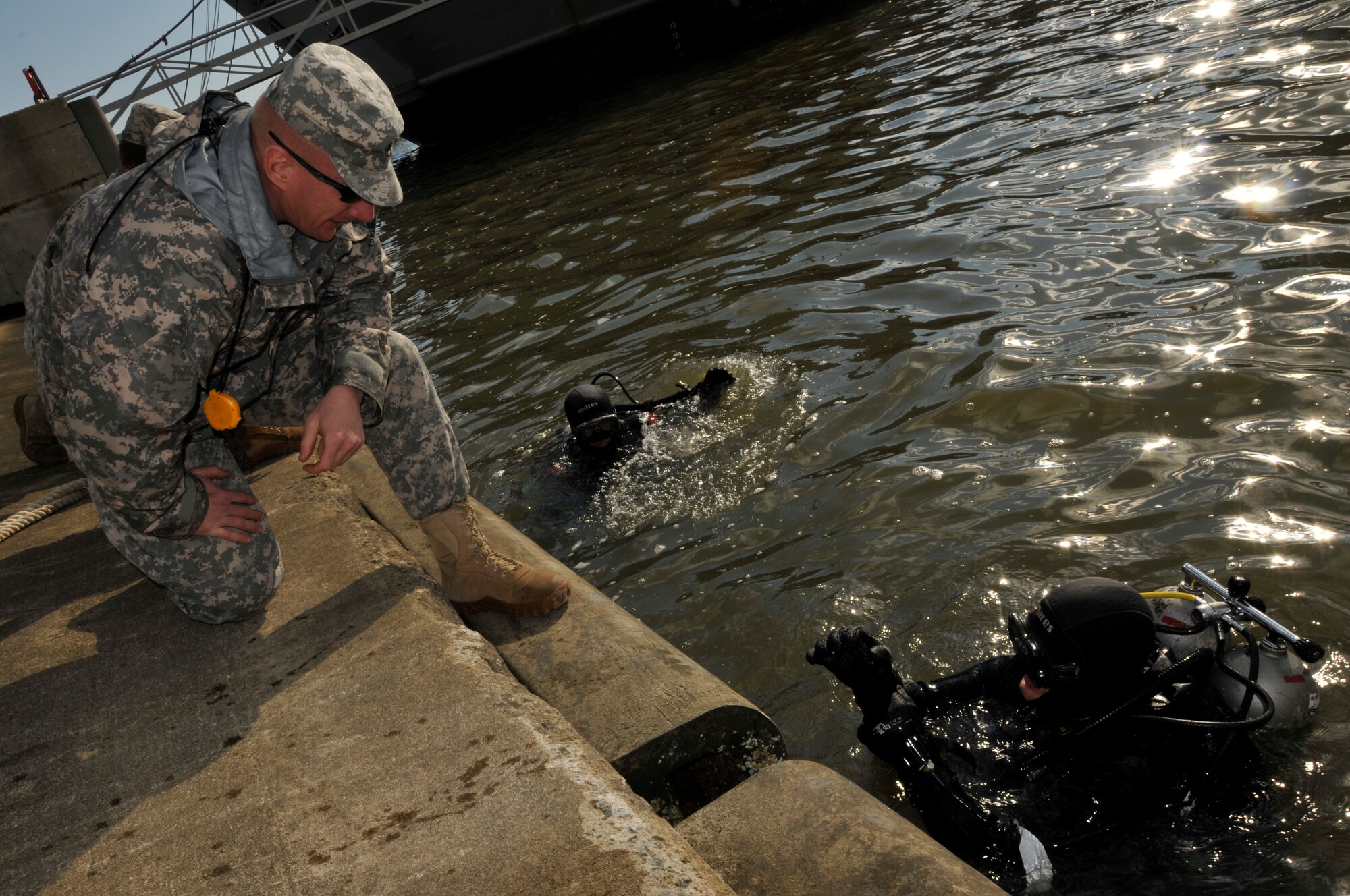 U.S. Army engineer divers assigned to the 74th Dive Detachment work on patching a portion of the Large Tug-805 at Fort Eustis' 3rd Port Feb. 2. The divers began the two-day repair project Feb. 6. (U.S. Army photo by Sgt. 1st Class Kelly Jo Bridgwater/Released)