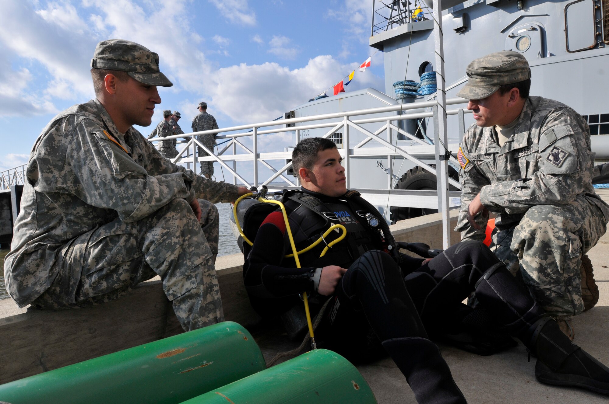 U.S. Army Spc. Javier Novoa (center), a 74th Dive Detachment engineer diver, serves as a standby diver with Spc. Kevin Nagel (left), on hand as Novoa's tender, and Staff Sgt. Humberto Santiago (right), supervising while members of the detachment work on patching a portion of the Large Tug-805 at Fort Eustis' 3rd Port Feb. 2, 2012. (U.S. Army photo by Sgt. 1st Class Kelly Jo Bridgwater/Released)