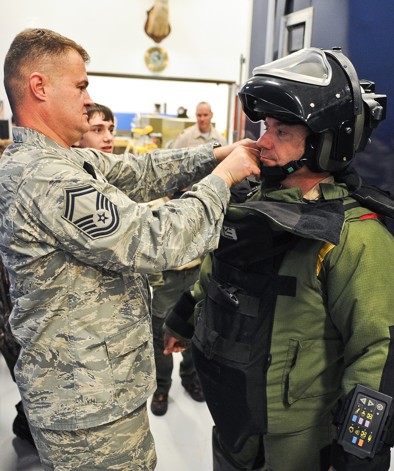 Air National Guard Senior Master Sgt. John Bell, 116th Civil Engineering Squadron explosive ordnance technician (EOD), left, helps Assistance Scout Master, John Sandusky, from Troop 51 out of Forsyth, Ga., during a demonstration of the EOD 9 bomb suit, Robins Air Force Base, Ga., Jan. 22, 2012.  The scouts were given a tour of the EOD unit during a field trip to Robins Air Force Base. (National Guard photo by Master Sgt. Roger Parsons/Released)