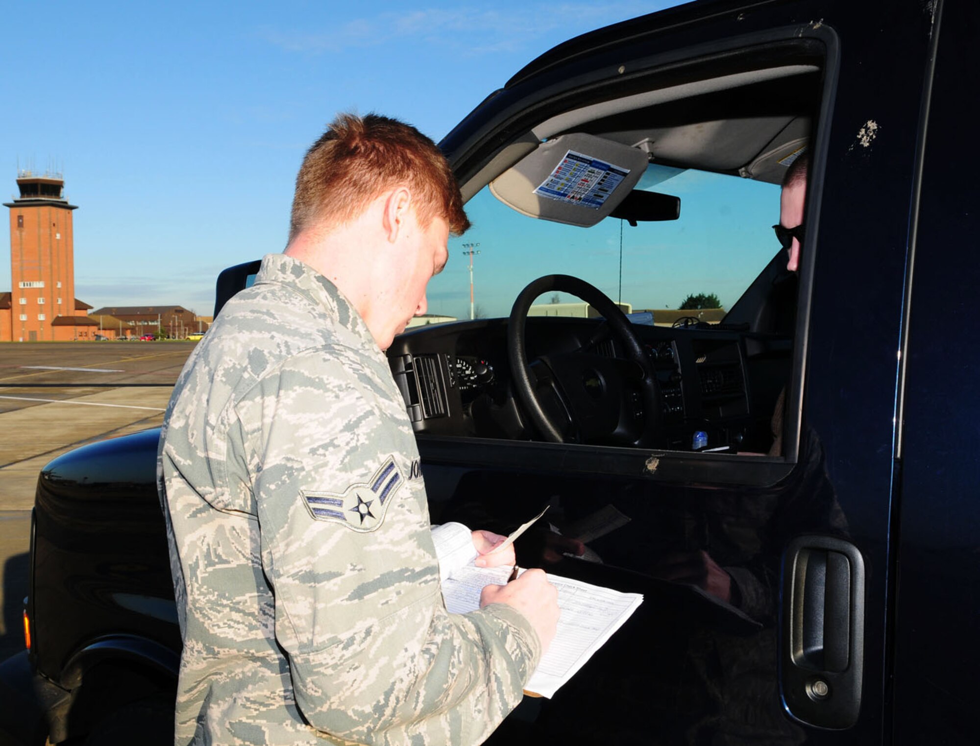 RAF MILDENHALL, England -- Airman 1st Class Caleb Johnson, 100th Operations Support Squadron Airfield Management Operations Flight, performs a random spot check on a military member driving a government vehicle on the flightline Jan. 12, 2012, to ensure the driver has a valid license and is certified to drive in this area. (U.S. Air Force photo/Karen Abeyasekere)