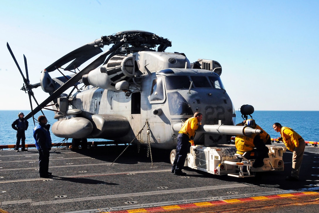 Sailors aboard the multipurpose amphibious assault ship USS Iwo Jima prepare to move a HSC-22 Sea Knight helicopter inside the hangar bay in the Atlantic Ocean, Jan. 30, 2012. The Iwo Jima Amphibious Ready Group is participating in Bold Alligator 2012 and conducting a final certification exercise to prepare for an upcoming deployment.