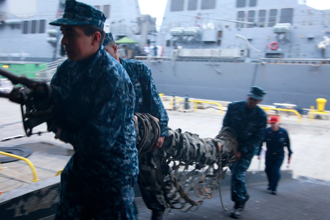 Sailors with the USS Peleliu load gear from the pier on to the ship, Feb. 7. Marines and sailors with the 15th Marine Expeditionary Unit, and soldiers with the Japanese Ground Self-Defense Force, are participating in a week-long at-sea period during Exercise Iron Fist 2012, which encompasses all aspects of the Marine Air Ground Task Force during the amphibious landing on to the island and provides the Navy/Marine Corps team an opportunity to practice their craft. Exercise Iron Fist 2012 is a bilateral training exercise, which gives the 15th MEU a chance to demonstrate its amphibious capabilities to the Japanese.