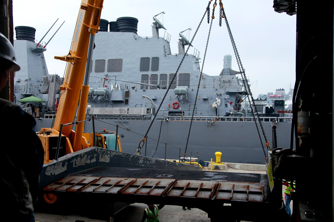 Civilian contractors remove the ramp loading troops on to the USS Peleliu, Feb. 7. Marines and sailors with the 15th Marine Expeditionary Unit, and soldiers with the Japanese Ground Self-Defense Force, are participating in a week-long at-sea period during Exercise Iron Fist 2012, which encompasses all aspects of the Marine Air Ground Task Force during the amphibious landing on to the island and provides the Navy/Marine Corps team an opportunity to practice their craft. Exercise Iron Fist 2012 is a bilateral training exercise, which gives the 15th MEU a chance to demonstrate its amphibious capabilities to the Japanese.