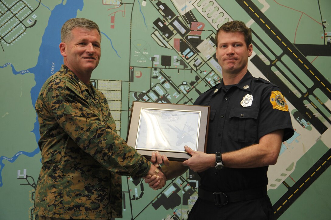 (Left to right) Col. Philip J. Zimmerman, commanding officer of Marine Corps Air Station Cherry Point, presents an award to Paul F. Ringheiser III, a paramedic and firefighter with the air station fire department, at Fire Station #1 Feb. 8, 2012. Ringheiser was commended for his inspiration behind the theme, “Celebrate the Heritage,” for this year’s MCAS Cherry Point Air Show May 4-6.