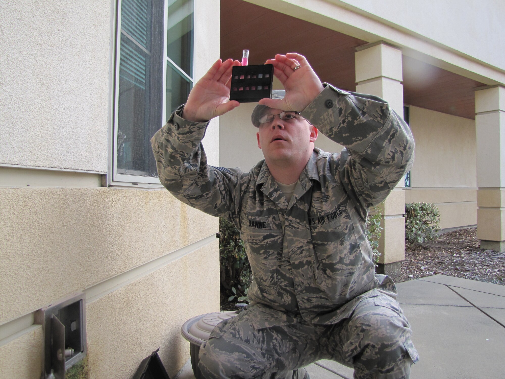 Tech. Sgt. John Danne, 60th Medical Group bioenvironmental flight NCO in charge of environmental protection elements, tests the water on Travis Sunday for heightened levels of chlorine. (courtesy photo)
