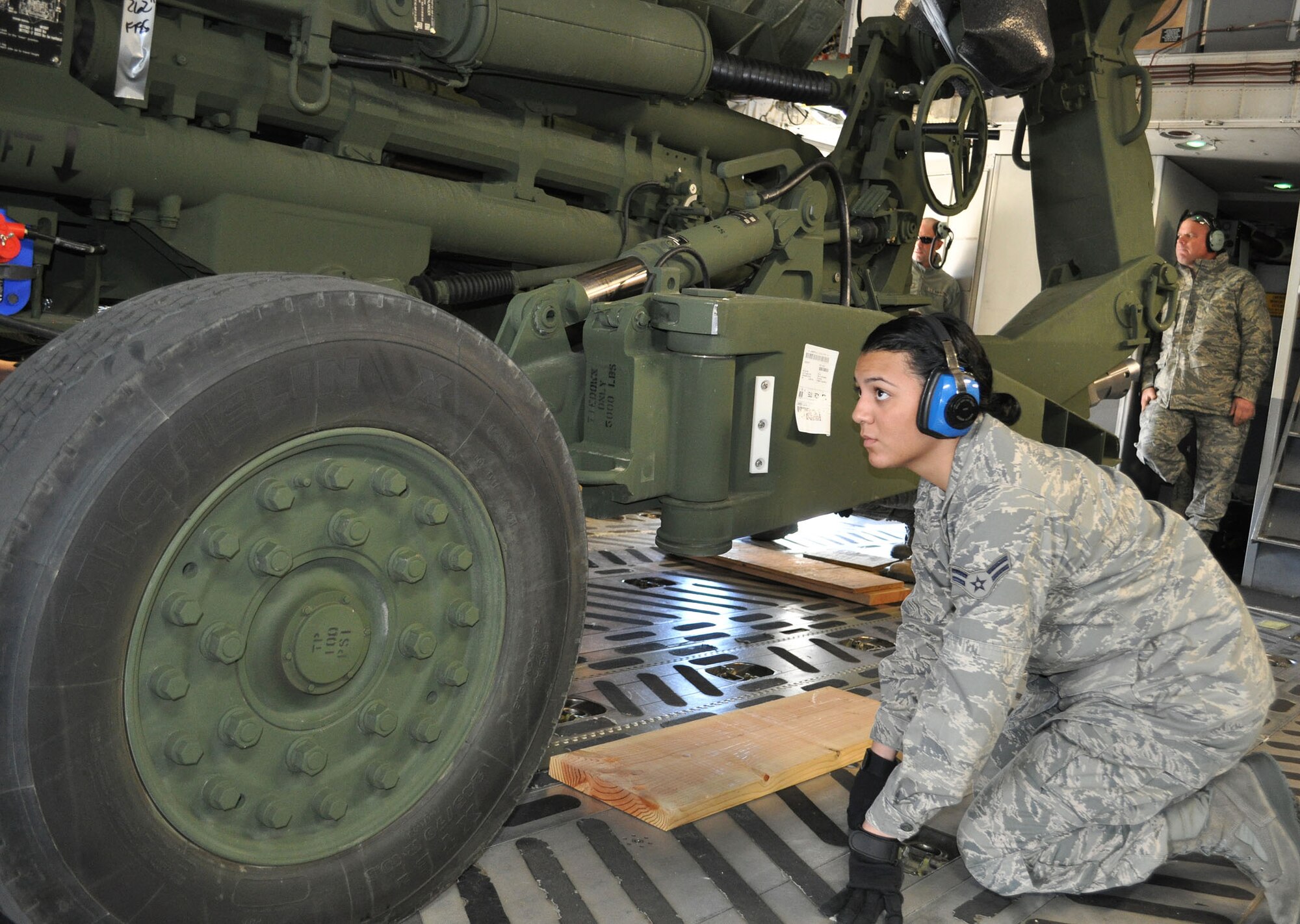 TRAVIS AIR FORCE BASE, Calif. -- Airman 1st Class Vanuce Dias Dos Santos spots a howitzer into position aboard a C-5. A reservist assigned to the 349th Air Mobility Wing's 55th Aerial Port Squadron, she was working with a Travis team of port "dawgs" to load two howitzers and eight pallets on the aircraft, for transport "down under." The 60th partners with the Reserve's 45th, 55th and 82nd APS regularly, on training and getting the job done. This particular job was being evaluated Feb. 3. (U.S. Air Force photo/Senior Master Sgt. Ellen Hatfield)