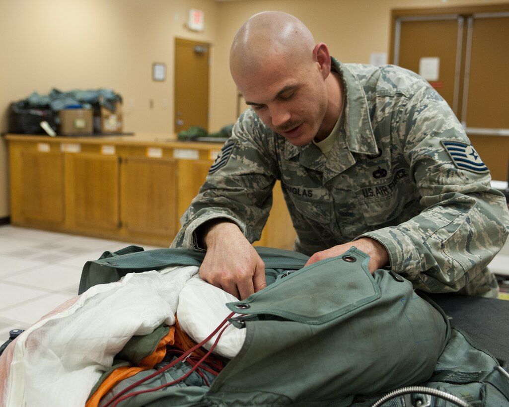 Tech. Sgt. Ian Douglas, 28th Operations Support Squadron, aircrew flight equipment NCO in charge, performs a quality assurance inspection to ensure a chute is properly packed at Ellsworth Air Force Base, S.D., Jan. 24, 2012. Before chutes are put into service, each one must pass a rigorous inspection to ensure it functions properly. (U.S. Air Force photo by Airman Alystria Maurer/Released)