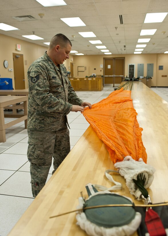 Staff Sgt. Andrew Wahlin, 28th Operations Support Squadron aircrew flight equipment craftsman, checks for any defects on the C-9 canopy during a parachute inspection at Ellsworth Air Force Base, S.D., Jan. 24, 2012. The entire canopy is inspected to ensure aircrews are equipped with serviceable safety gear. (U.S. Air Force photo by Airman Alystria Maurer/Released)