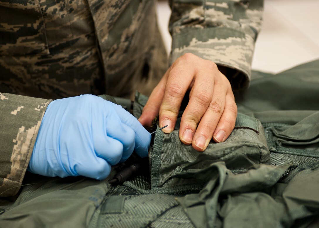 Staff Sgt. Andrew Wahlin, 28th Operations Support Squadron aircrew flight equipment craftsman, secures a beacon antenna to a parachute harness at Ellsworth Air Force Base, S.D., Jan. 24, 2012. Wahlin replaced the outdated version of the beacon antenna with more current and advanced equipment. (U.S. Air Force photo by Airman Alystria Maurer/Released)