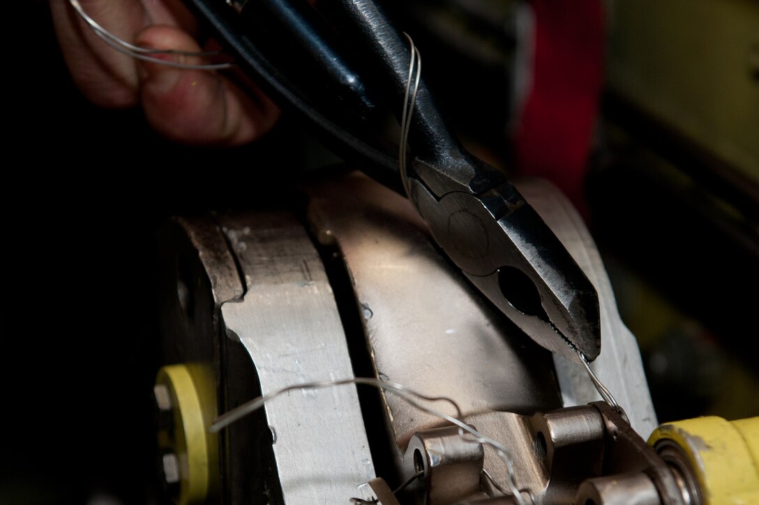 Senior Airman Andrew Knill, 28th Maintenance Squadron hydraulics specialist, tightens safety wire to secure a bolt on a B-1B integrated servo actuator during a maintenance inspection at Ellsworth Air Force Base, S.D., Feb. 2, 2012. Safety-wiring reduces the risk of bolts vibrating loose during aircraft operations, eliminating potential mechanical failure and foreign object debris.  (U.S. Air Force photo by Airman 1st Class Kate Thornton/Released)