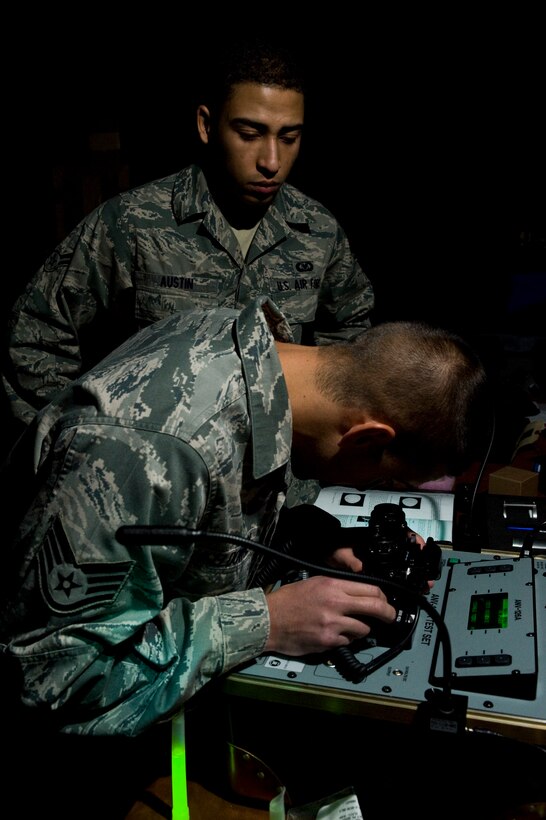 Staff Sgt. Justin Mceldowney trains Airman 1st Class Nathan Austin, both 28th Operations Support Squadron aircrew flight equipment technicians how to test night vision goggles on Ellsworth Air Force Base, S.D., Nov. 16, 2011. Pilots use night vision goggles to train for and conduct lowlight missions, an essential part of all combat operations. (U.S. Air Force photo by Airman Alystria Maurer/Released)