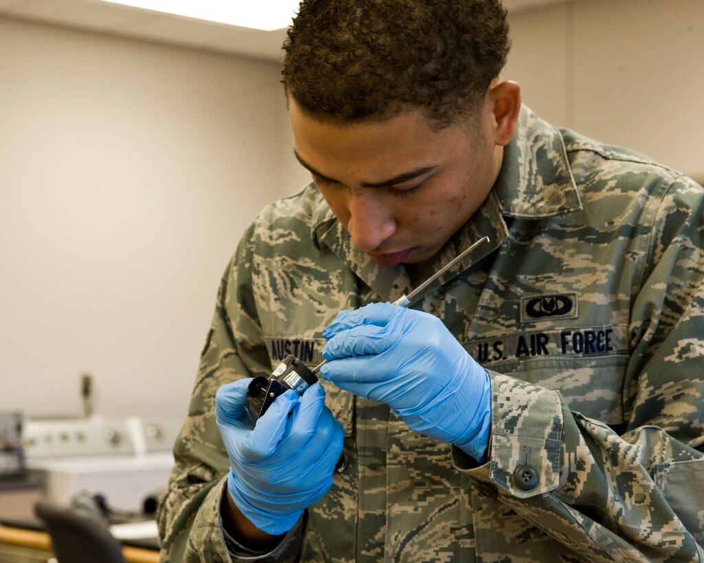 Airman 1st Class Nathan Austin, 28th Operations Support Squadron aircrew flight equipment technician, removes an o-ring seal from a CRU-60/P hose from a pilot’s helmet on Ellsworth Air Force Base, S.D., Nov. 16, 2011.  The o-ring seals must be cleaned often to ensure that dirt and bacteria are removed so pilots have clean and serviceable equipment. (U.S. Air Force photo by Airman Alystria Maurer/Released)