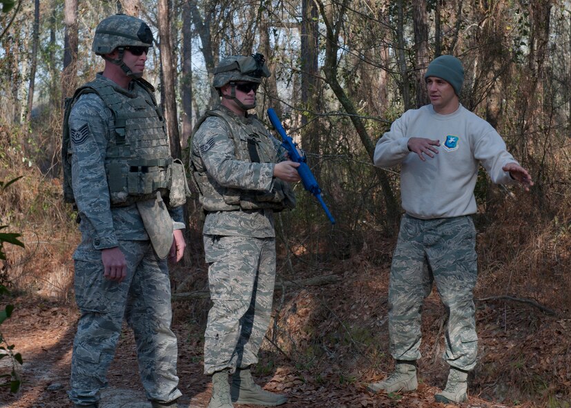 U.S. Air Force Tech. Sgt. Dallas Bozeman, 820th Combat Operations Squadron explosive ordnance disposal technician, instructs other members of his squadron on how to tactically maneuver through the woods to locate improvised explosive devices at the military operations in urban terrain village Feb. 8, 2012 at Moody Air Force Base, Ga. Bozeman was recently awarded the Maj. Gen. Eugene A. Lupia non-commissioned officer category award for his successful performances down range. Along with his deployment, Bozeman was acknowledged for the humanitarian work he did in Tuscaloosa, Ala., aiding the citizens of the town who had been devastated from a violent tornado. (U.S. Air Force photo by Senior Airman Eileen Meier/Released)