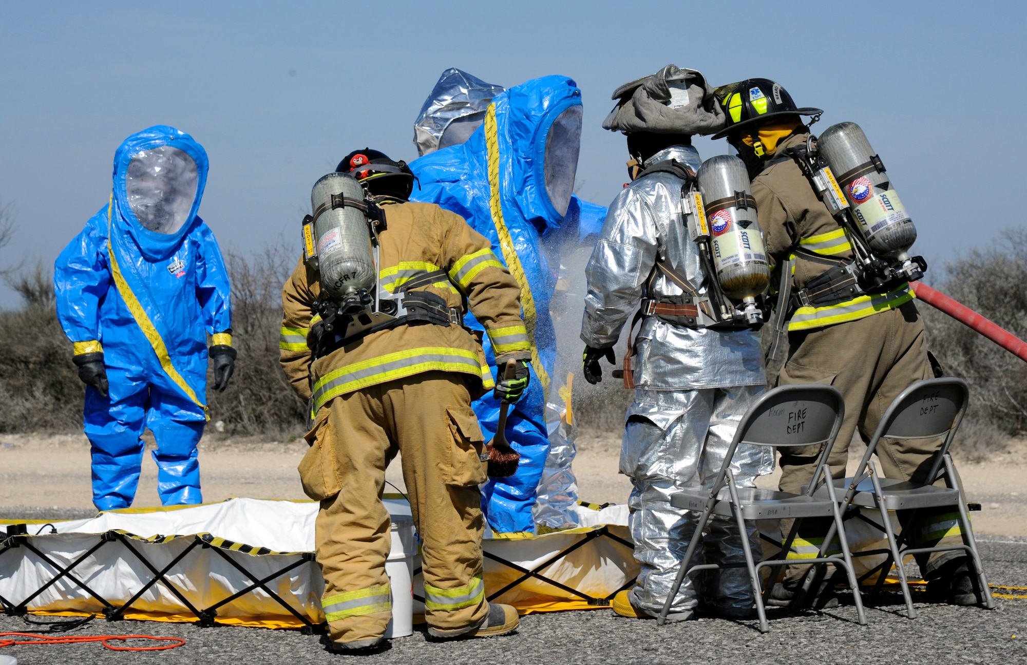 LAUGHLIN AIR FORCE BASE, Texas -- Kinney County and Laughlin firefighters decontaminate Laughlin's hazardous material responders after they completed a sweep of the crash site 11 miles east of Laughlin Feb. 7. Laughlin first responders led the initial response to the 30-car train derailment by sending a HAZMAT team to ensure the crash site was free of potentially hazardous material. (U.S. Air Force photo/Airman 1st Class Nathan L. Maysonet)