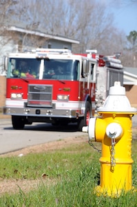 Firefighters from the 628th Civil Engineer Squadron, Civil Engineer Fire Department’s Station Six, respond to a simulated fire at a home in the MenRiv Housing area at Joint Base Charleston - Weapons Station during an exercise Feb. 2.  The first fire truck to report on scene is required to be in position within four to seven minutes of the emergency call. A second truck arrives on the scene within seven to 10 minutes to assist the first truck. (U.S. Navy photo/Petty Officer 1st Class Jennifer Hudson)
