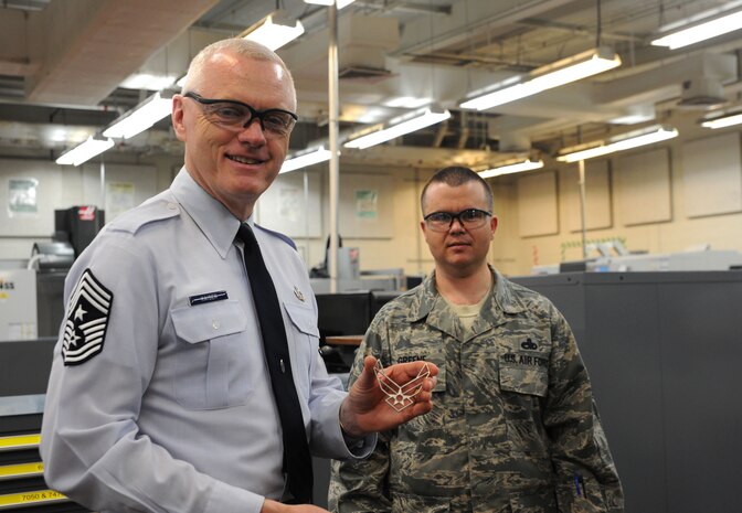Chief Master Sgt. Richard "Andy" Kaiser receives an Air Force symbol from Master Sgt. George Greene at Joint Base Charleston - Air Base Feb. 6. Kaiser is the Air Mobility Command command chief and is the principal advisor to the commander and his senior staff on matters of health, welfare and morale, professional development and the effective utilization of more than 43,000 active duty and 71,000 Air Force Reserve Command and Air National Guard enlisted personnel assigned to the command. Greene is a 437th Maintenance Squadron, 437th Airlift Wing section chief of metals technology. (U.S. Air Force photo/Airman 1st Class Ashlee Galloway)