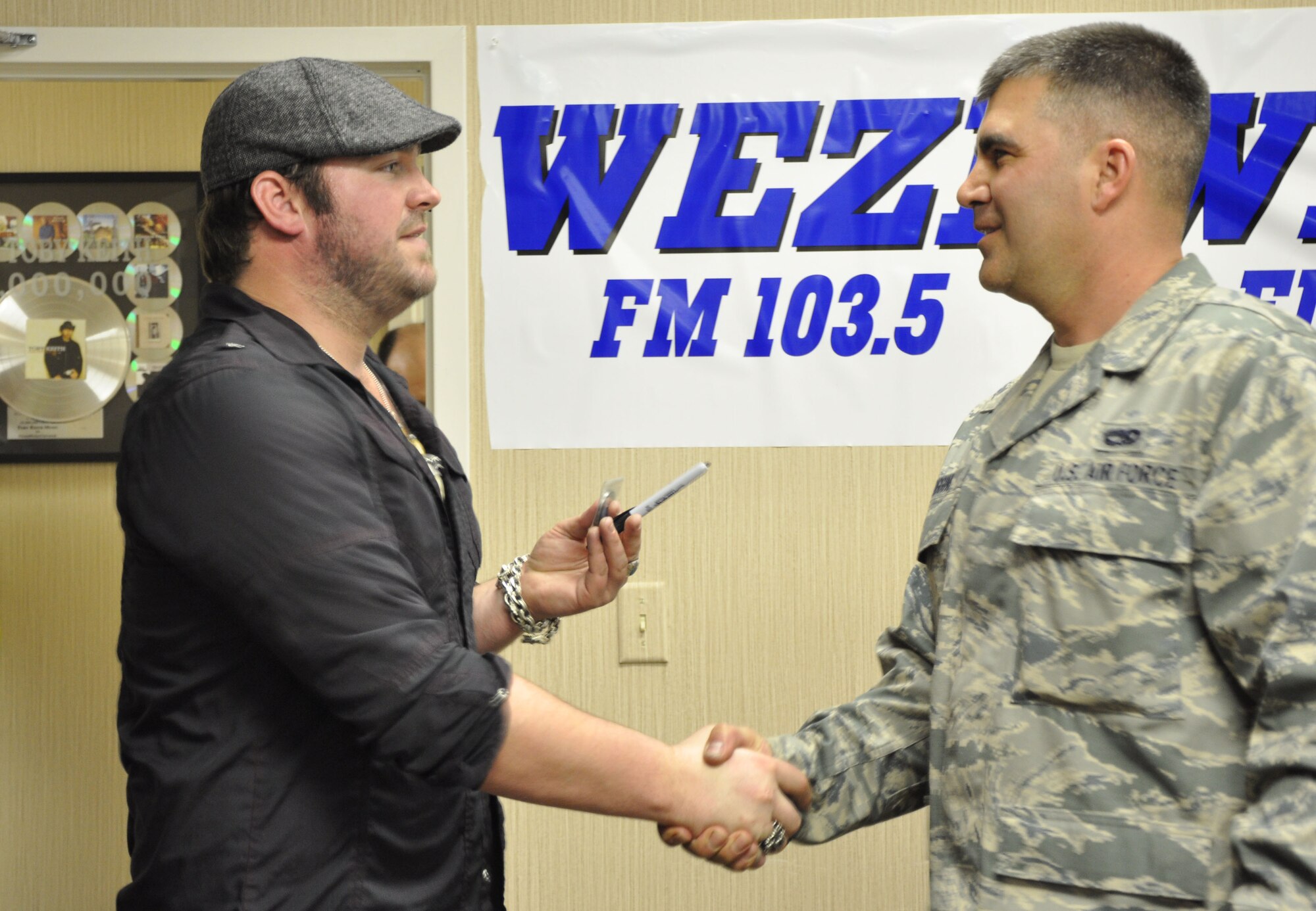 Staff Sergeant Justin Diggins presents country music artist Lee Brice with a 315th Airlift Wing coin WEZL FM in Mt Pleasant S.C. Four reservists from the 315th Airlift Wing, Joint Base Charleston S.C. participated in a meet and greet and were treated to a performance of some of Lee's latest hits. 